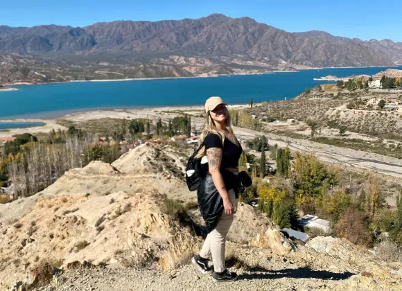 Mujer disfrutando de un día soleado de verano a orillas del Dique Potrerillos.