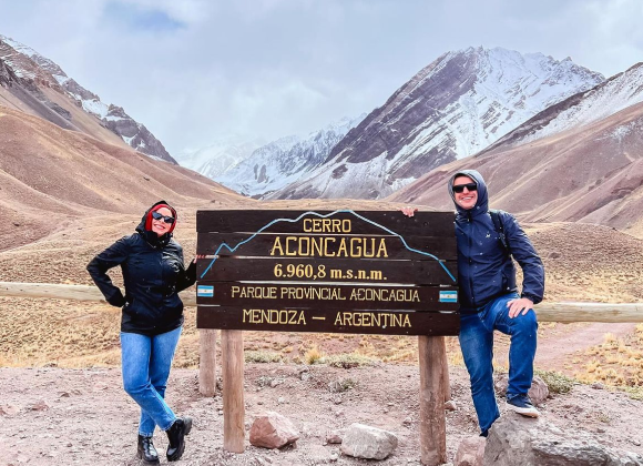 Pareja con ropa de invierno disfrutando excursion a potrerillos.